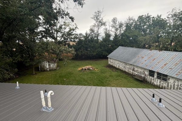 Building with a newly installed tan metal roof featuring ribbed or standing seam panels for long-lasting, low-maintenance weather resistance.