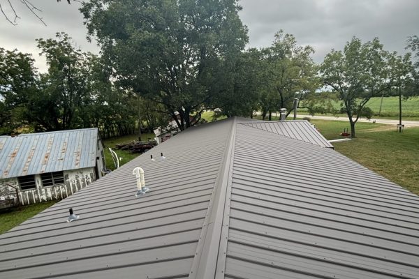 Recently installed dark gray metal roof with rib-type exposed fastener panels offering durable, low-maintenance, and weather-resistant performance.