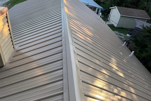 New standing seam metal roof installation on a residential building featuring raised interlocked seams for concealed fasteners, durable metal panels, and a modern clean appearance.