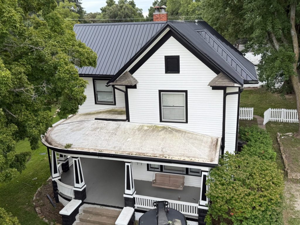 Two-story house with a newly installed black metal roof, likely completed by KM Roofing Solutions LLC.