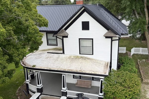 Two-story house with a newly installed black metal roof, likely completed by KM Roofing Solutions LLC.