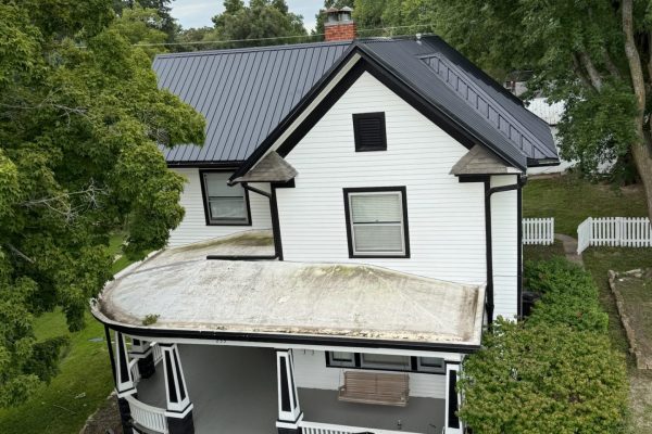 Two-story house with a newly installed black metal roof, likely completed by KM Roofing Solutions LLC.