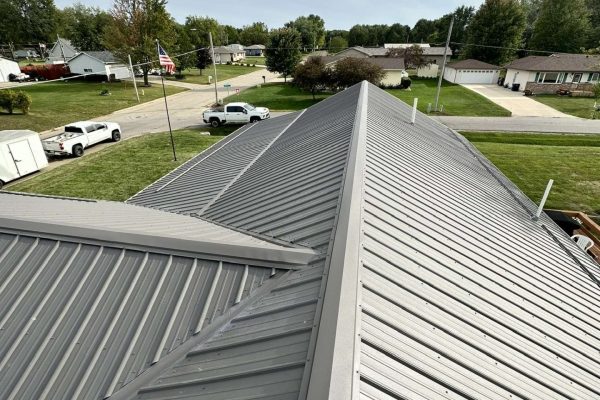 Standing seam metal roof installation on a residential building with raised interlocking seams and concealed fasteners for durable, energy-efficient, and weather-resistant performance.