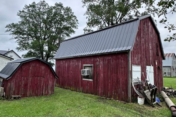 Barn with a gambrel-style roof featuring dual slopes that maximize interior loft or storage space and provide a classic rustic appearance.