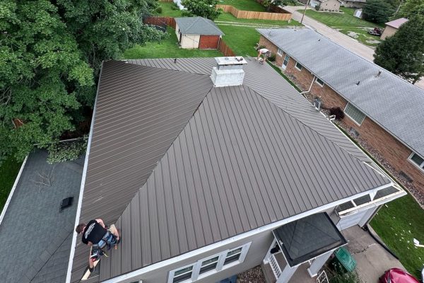 Standing seam metal roof installation on a residential home with concealed fasteners for durable, low-maintenance, energy-efficient, and sustainable performance.