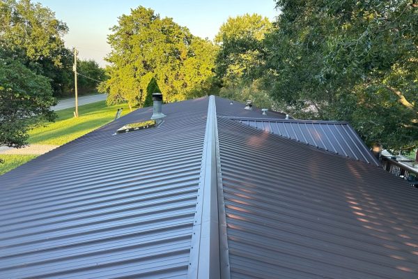 New standing seam metal roof installation with vertical interlocking panels, concealed fasteners, and a durable, energy-efficient, low-maintenance design.